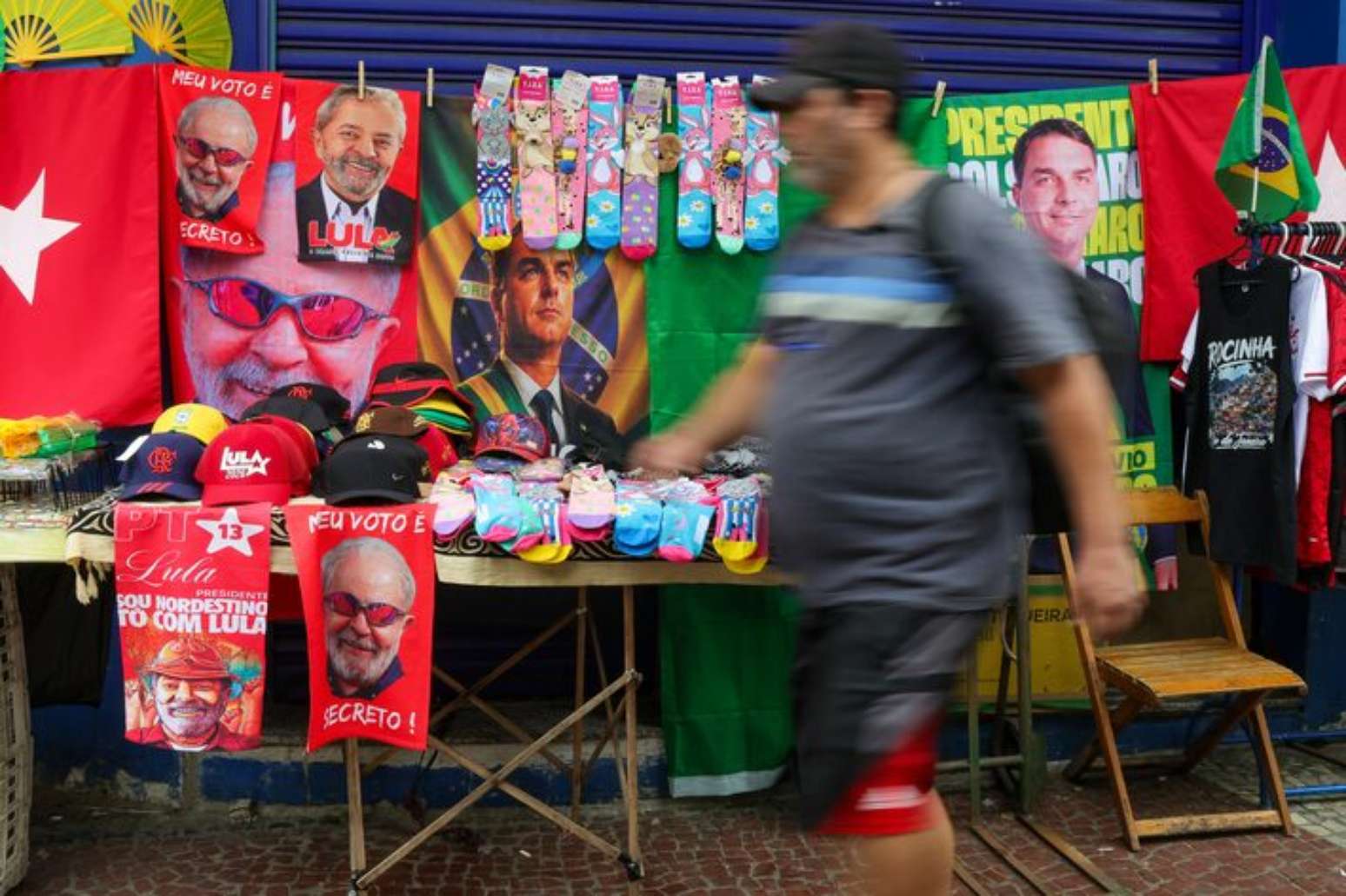 Ambulante com toalhas de Lula e Fl&aacute;vio Bolsonaro a venda na rua Siqueira Campos, em Copacabana, zona sul do Rio de Janeiro.