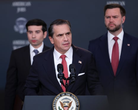 Attorney General Todd Blanche speaks at a podium as Vice President JD Vance listens behind him