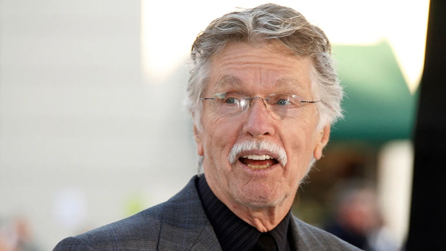 REUTERS/Fred Prouser/File Photo Actor Tom Skerritt is seen with his mouth open, apparently talking, and smiling. He is wearing a black buttoned-up shirt, rimless glasses and a grey suit coat. He appears to be outside.