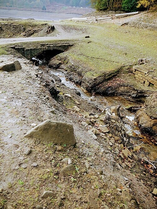 A historic bridge in the submerged village of Derwent becomes visible when the reservoir recedes. (Wikimedia Commons.)
