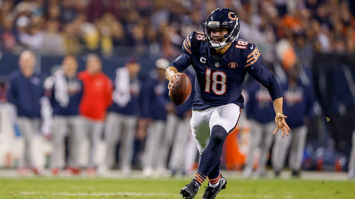 Caleb Williams runs the ball during an NFL game at Soldier Field.
