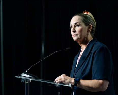 a woman stands at a lectern